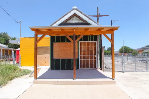 A small structure, the former Ruben's Ice House, is photographed under renovation, its windows boarded up. 